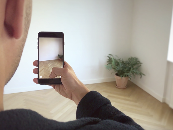 Uomo che tiene in mano il dispositivo mobile per sperimentare IKEA Place, un'applicazione AR per visualizzare i mobili